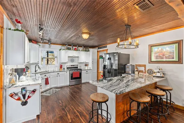 a open kitchen with stainless steel appliances granite countertop a stove and refrigerator