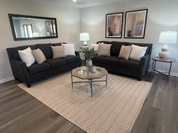 a living room with furniture and a wooden floor