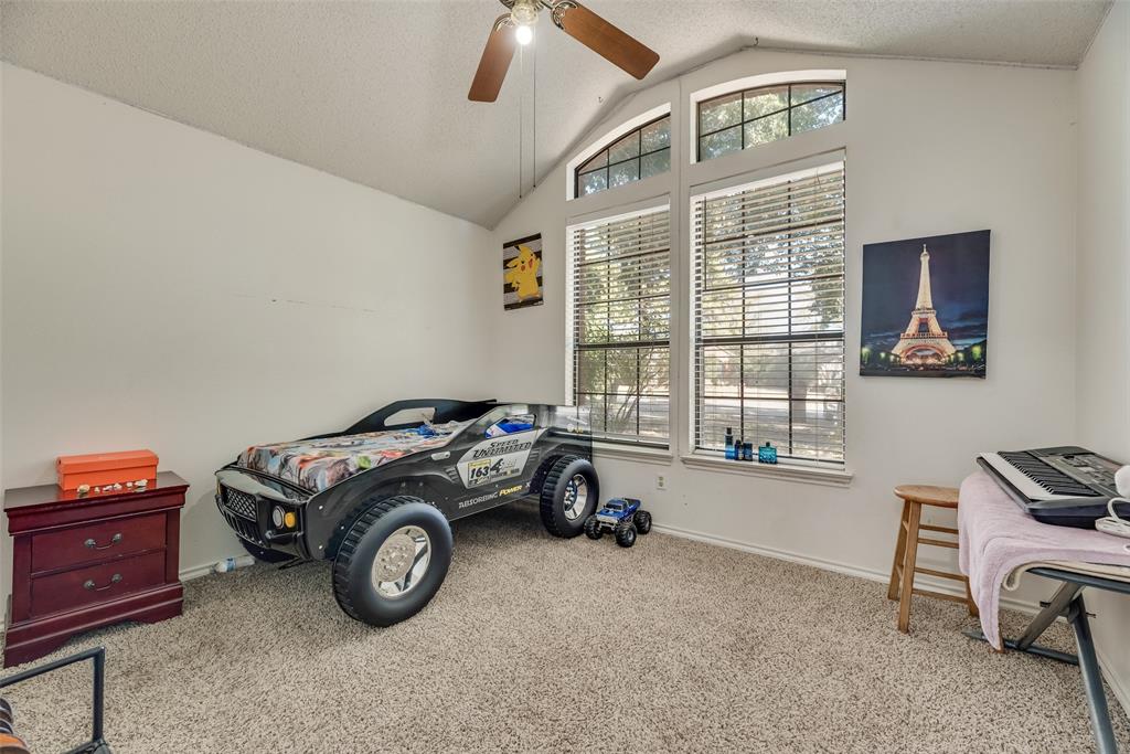 4102 Autumn Ridge Court Arlington, TX 76016 - Photo 11 of 20 Bedroom featuring a textured ceiling, vaulted ceiling, light colored carpet, and a ceiling fan