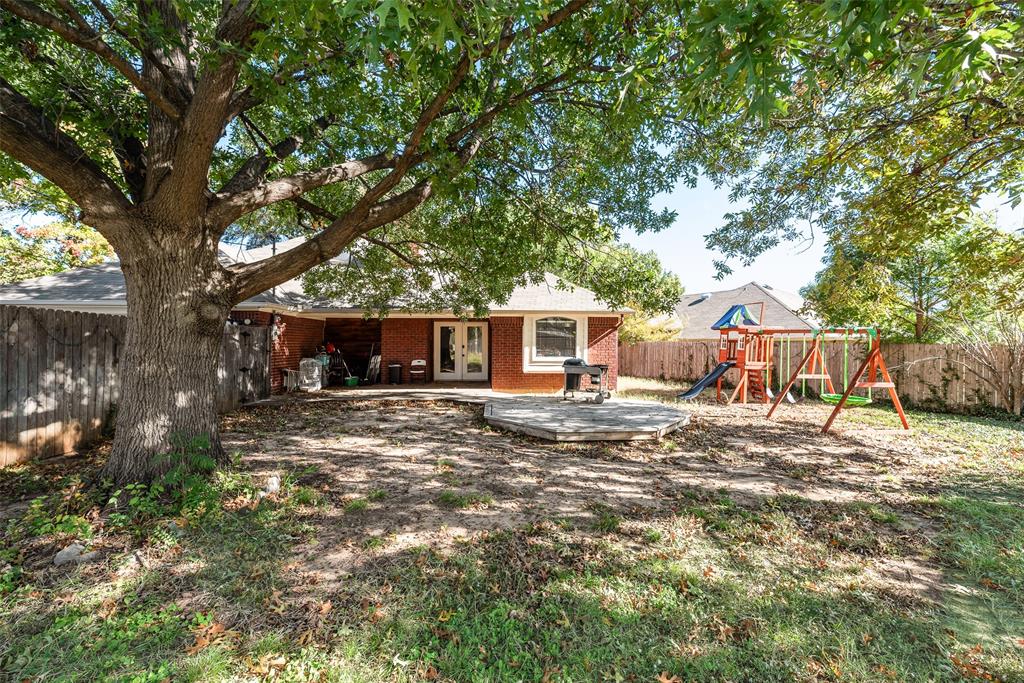 4102 Autumn Ridge Court Arlington, TX 76016 - Photo 18 of 20 Rear view of property featuring a fenced backyard, a playground, french doors, a patio, and brick siding