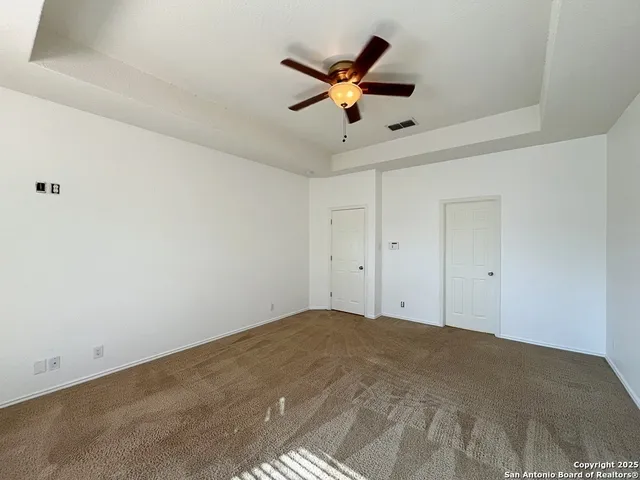 an empty room with a window and a fan