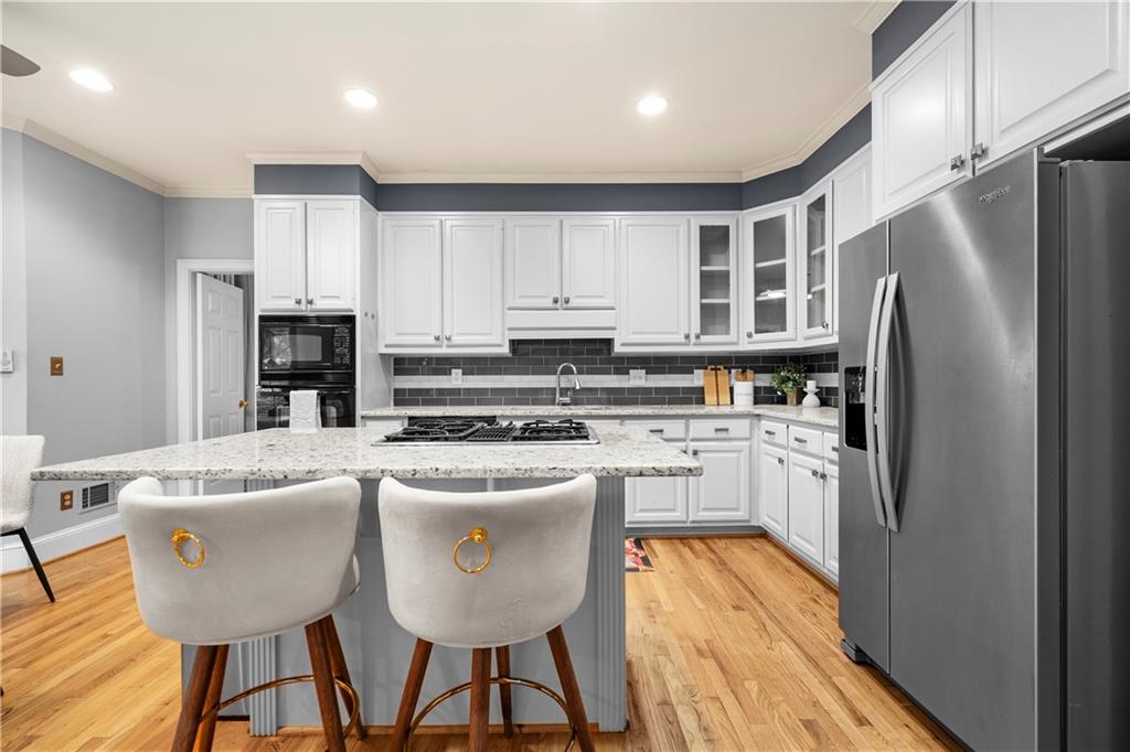 1696 Harts Run Atlanta, GA 30341 - Photo 21 of 55 a kitchen with stainless steel appliances granite countertop a refrigerator a stove a sink dishwasher and white cabinets with wooden floor