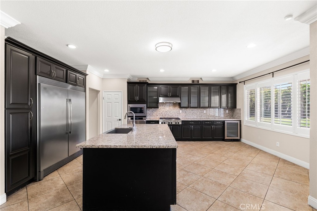 5105 Sanchez Court Rancho Cucamonga, CA 91739 - Photo 13 of 61 a large kitchen with stainless steel appliances kitchen island granite countertop a refrigerator and a sink
