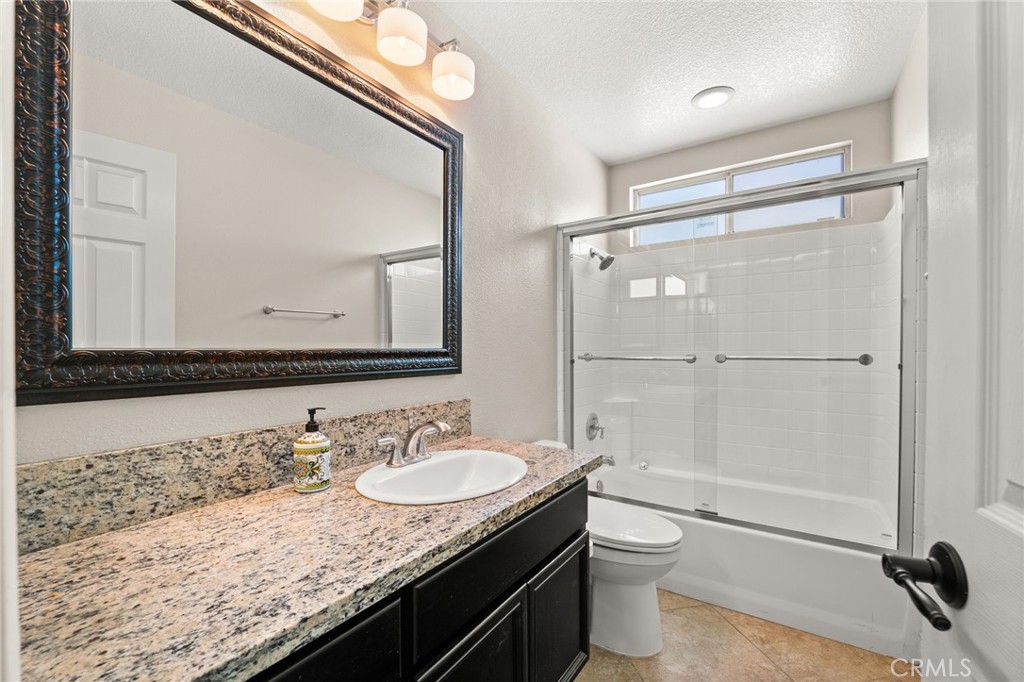 5105 Sanchez Court Rancho Cucamonga, CA 91739 - Photo 20 of 61 a bathroom with a granite countertop sink a toilet a mirror and shower