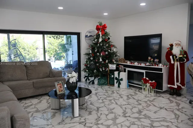 a living room with furniture a flat screen tv and a large window