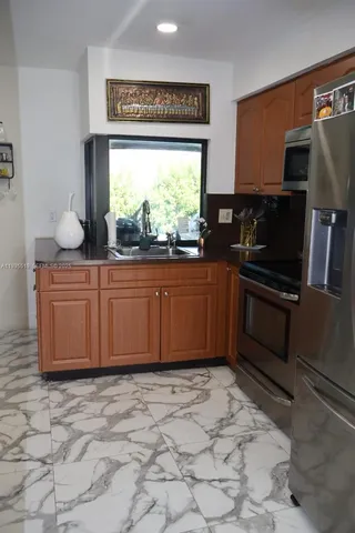 a kitchen with stainless steel appliances a sink and a refrigerator
