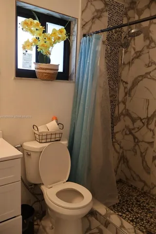 a white toilet sitting next to a shower curtain