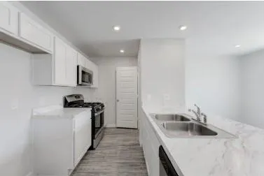 a kitchen with a sink a stove top oven and white kitchen