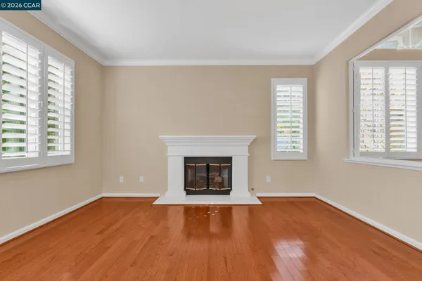 wooden floor in an empty room with a kitchen