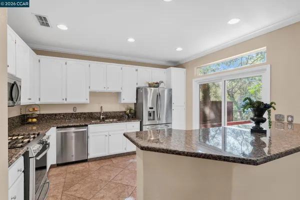 a kitchen with stainless steel appliances granite countertop a refrigerator and a sink