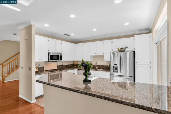 a kitchen with granite countertop a stove top oven and cabinets