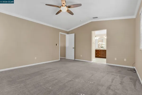 an empty room with wooden floor closet and chandelier fan