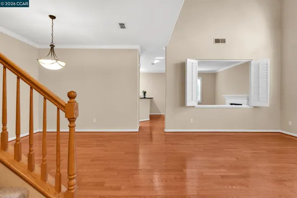 an empty room with windows and wooden floor