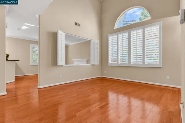 an empty room with window and wooden floor