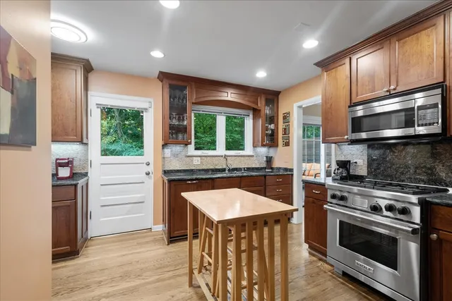 a kitchen with kitchen island granite countertop a stove and a sink