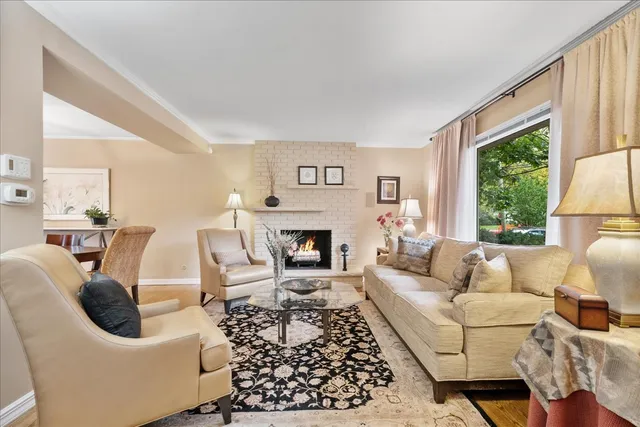 a living room with furniture a large window and a fireplace