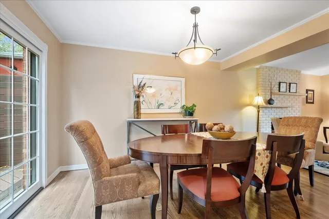 a dining room with furniture a chandelier and wooden floor