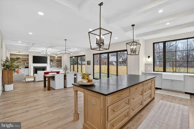 a large kitchen with kitchen island a large counter top space a sink appliances and living room view