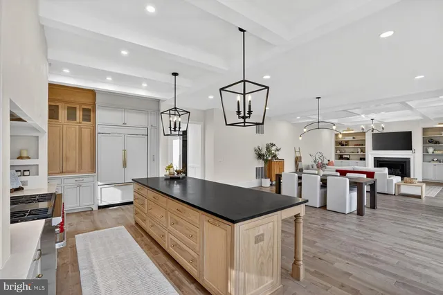 a living room with furniture kitchen view and a chandelier