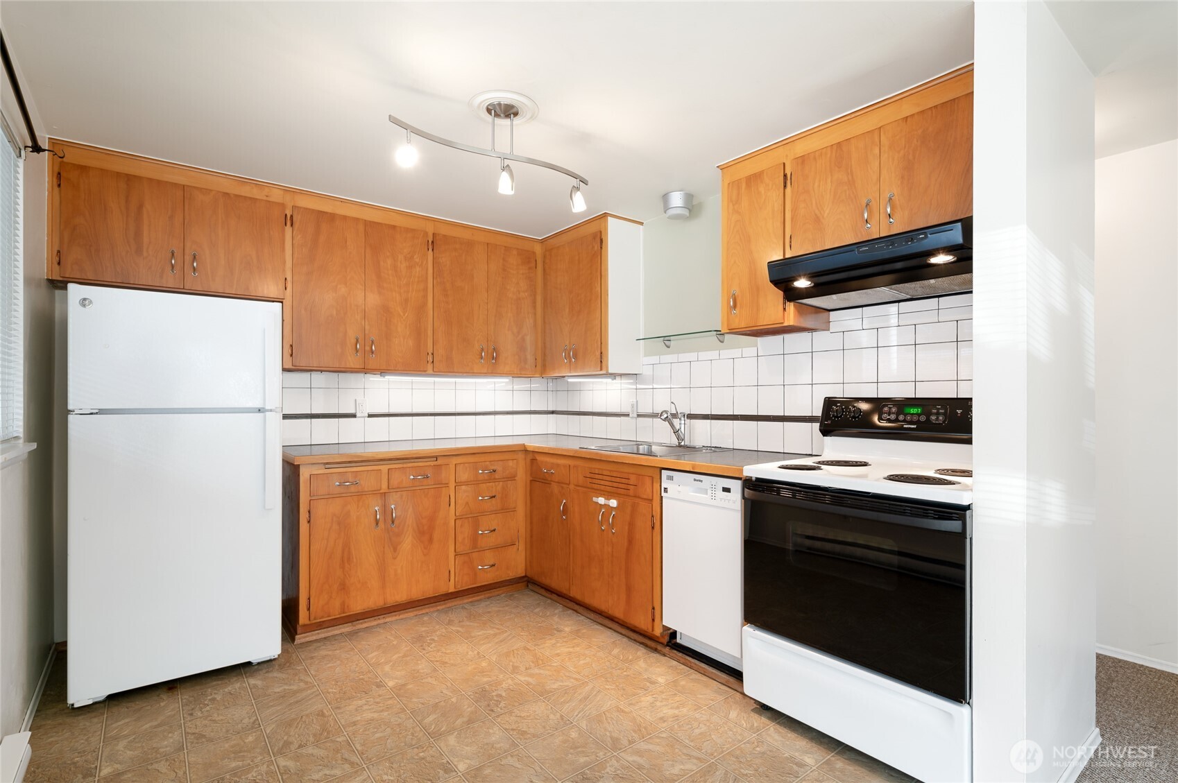 633 West Emerson Street Seattle, WA 98119 - Photo 18 of 25 a kitchen with stainless steel appliances granite countertop a refrigerator stove a sink dishwasher and microwave with cabinets