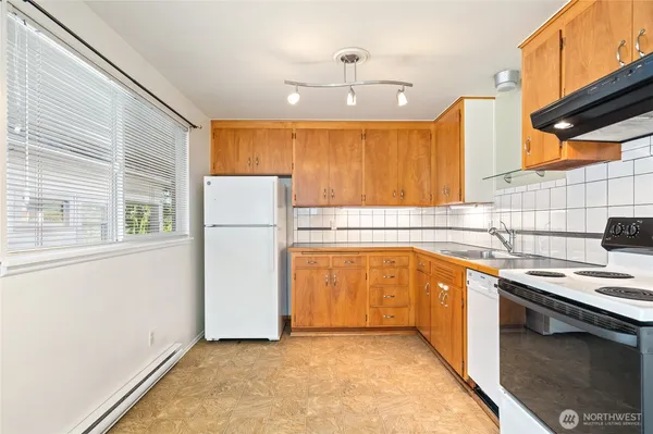 a kitchen with stainless steel appliances granite countertop a sink a stove and a refrigerator