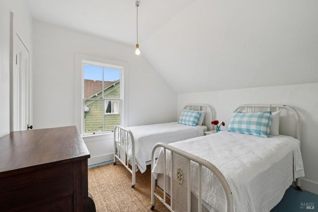 a backyard of a house with table and chairs under an umbrella