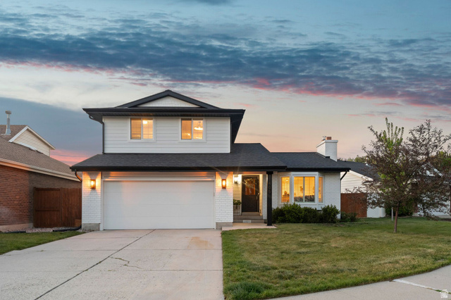 1405 Vintry Lane Murray, UT 84121 - Photo 2 of 44 Two-story residence featuring a two-car garage, white brick facade, and a dark shingle roof