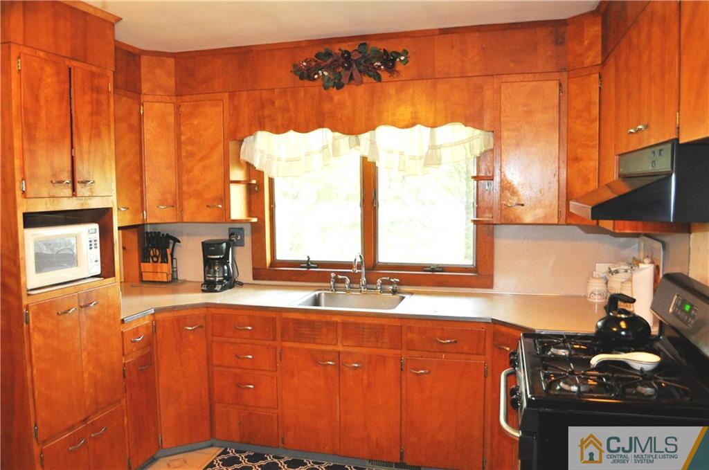 547 Ridge Road Monmouth Junction, NJ 08852 - Photo 13 of 25 a kitchen with stainless steel appliances a sink cabinets and a large window