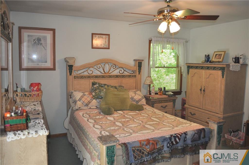 547 Ridge Road Monmouth Junction, NJ 08852 - Photo 21 of 25 a bedroom with a bed and a chandelier