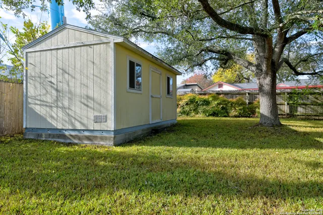 a view of backyard of house with wooden fence
