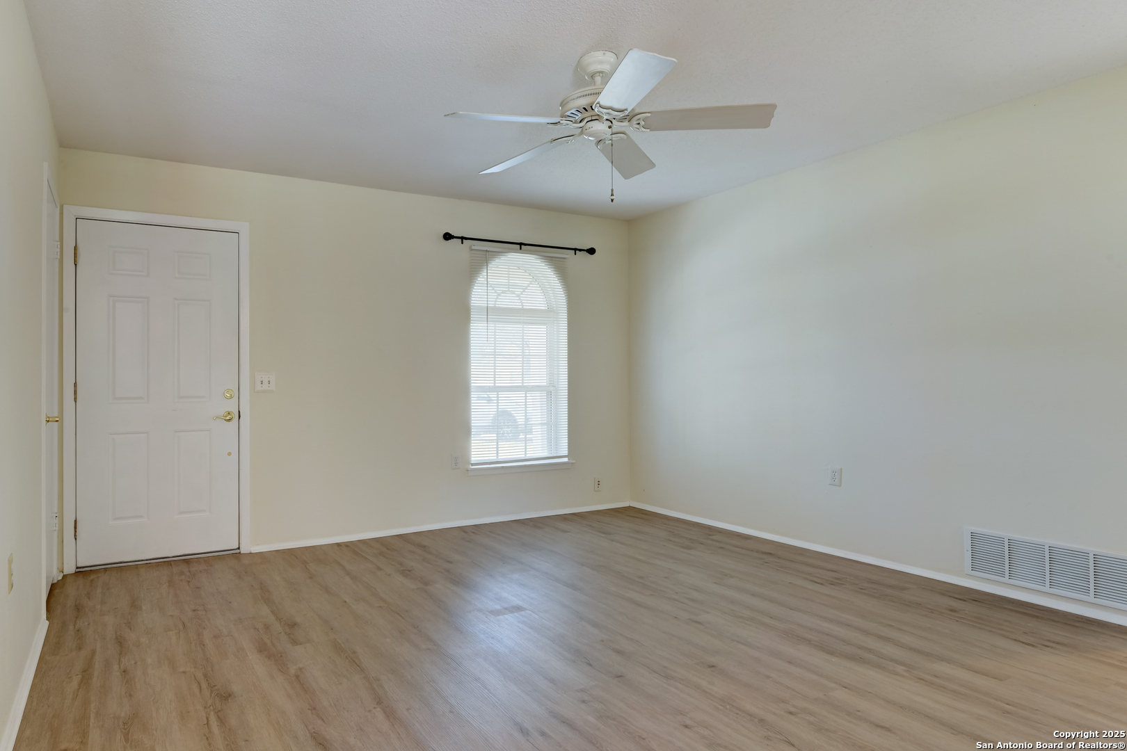 12401 Trailing Oaks Street Live Oak, TX 78233 - Photo 23 of 31 an empty room with wooden floor chandelier fan and windows