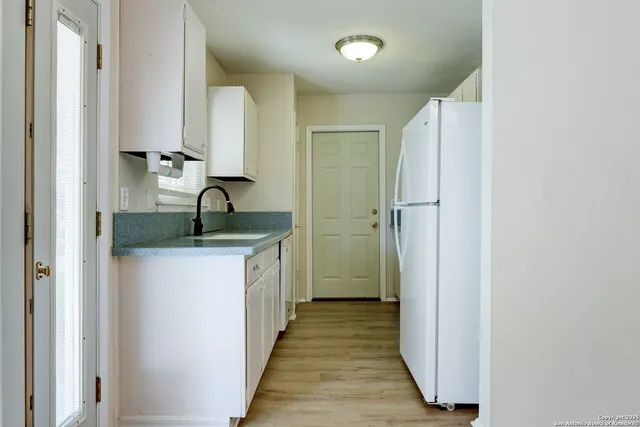 a kitchen with a refrigerator and a sink