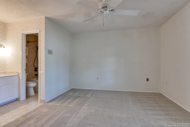 an empty room with chandelier fan