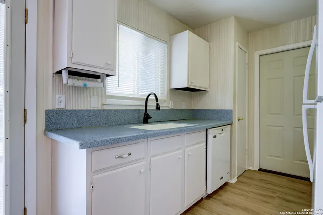 a kitchen with white cabinets and a sink