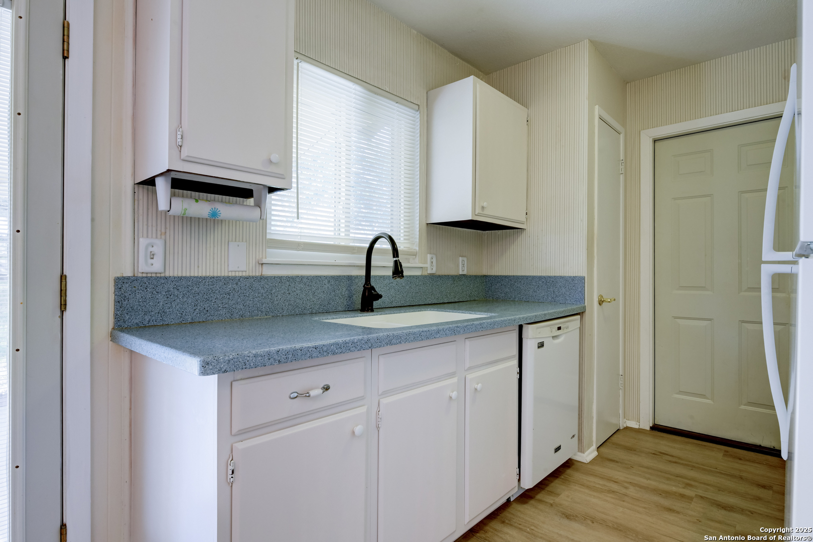 12401 Trailing Oaks Street Live Oak, TX 78233 - Photo 6 of 31 a kitchen with white cabinets and a sink