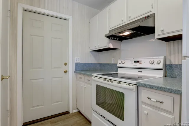 a kitchen with stainless steel appliances granite countertop white cabinets and a stove