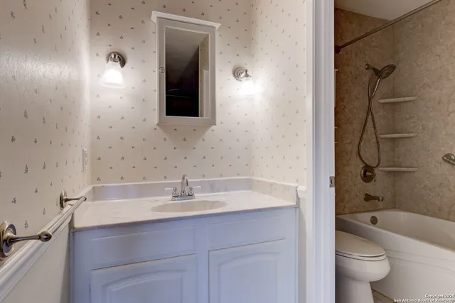 a bathroom with a sink a toilet and shower