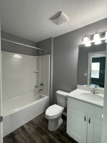 an empty room with wooden floor and window