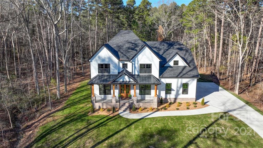 an aerial view of a house with swimming pool and porch