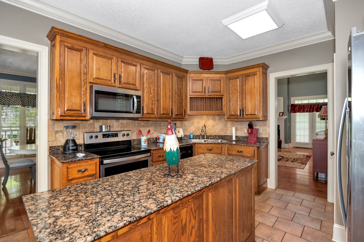 21 Meeting House Road Ardmore, TN 38449 - Photo 18 of 62 a kitchen with stainless steel appliances granite countertop a stove top oven a sink dishwasher a refrigerator and a microwave