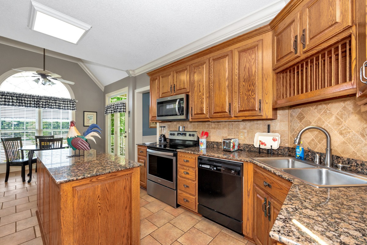 21 Meeting House Road Ardmore, TN 38449 - Photo 20 of 62 a kitchen with granite countertop a stove top oven a sink dishwasher a dining table and chairs with wooden floor