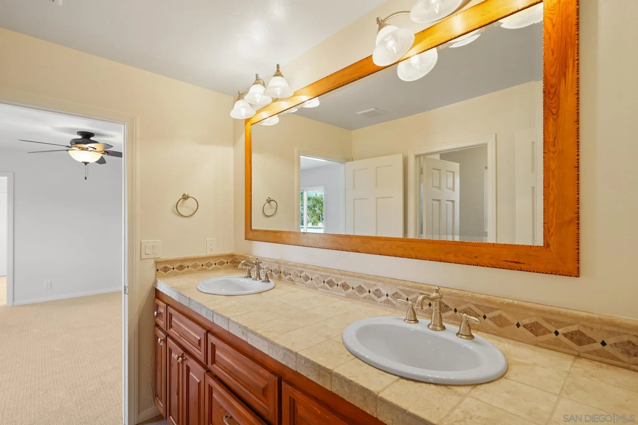 1482 Rancho Encinitas Drive Encinitas, CA 92024 - Photo 68 of 75 a bathroom with a granite countertop sink and a mirror