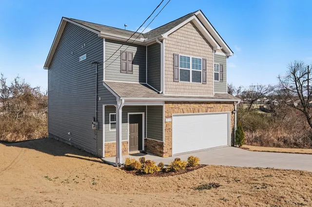 a front view of a house with a yard and garage