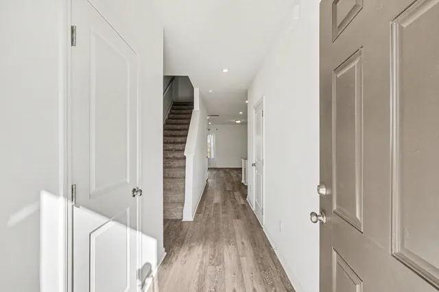 a view of a hallway with wooden floor and staircase