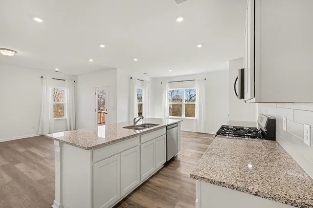 a kitchen with granite countertop sink and cabinets