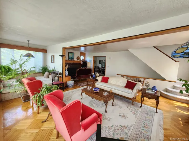 a living room with furniture a rug and a floor to ceiling window