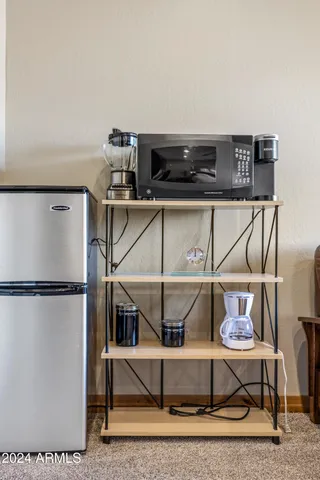 a front view of a house with a dirt yard and a large window