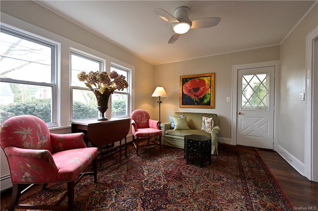 a living room with furniture large window and wall painting