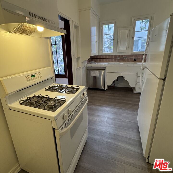 328 North Sycamore Avenue Los Angeles, CA 90036 - Photo 15 of 29 a kitchen with a stove and a refrigerator