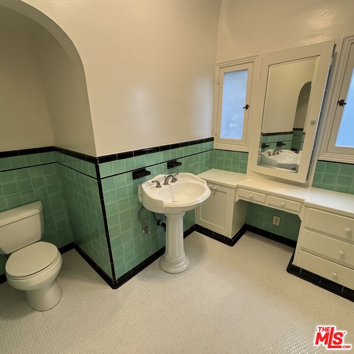 328 North Sycamore Avenue Los Angeles, CA 90036 - Photo 20 of 29 a bathroom with a sink toilet and a mirror